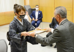 奄美観光大使の委嘱状を受け取る緒方さん（左）＝８日、奄美市名瀬