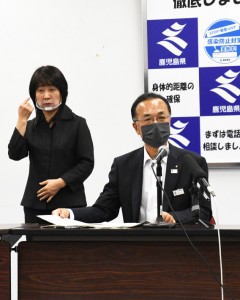 記者会見で県の感染状況などについて述べる谷口くらし保健福祉部長（右）＝１日、鹿児島市の県庁